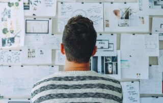 man looking at a board of ideas