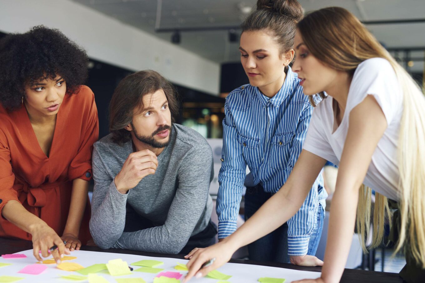 Coworkers discussing ideas written on sticky notes
