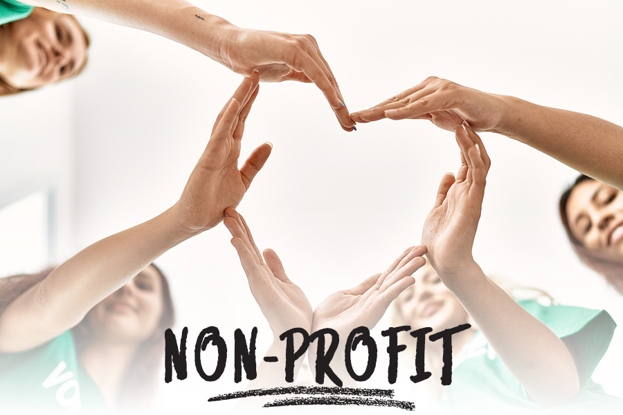 a group of volunteers making a heart shaped design with interconnected hands