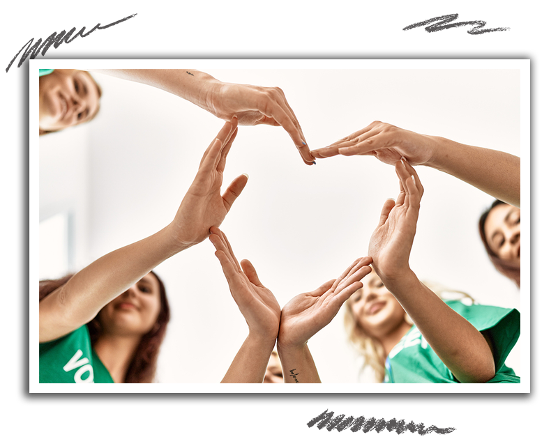 a group of volunteers making a heart shaped design with interconnected hands