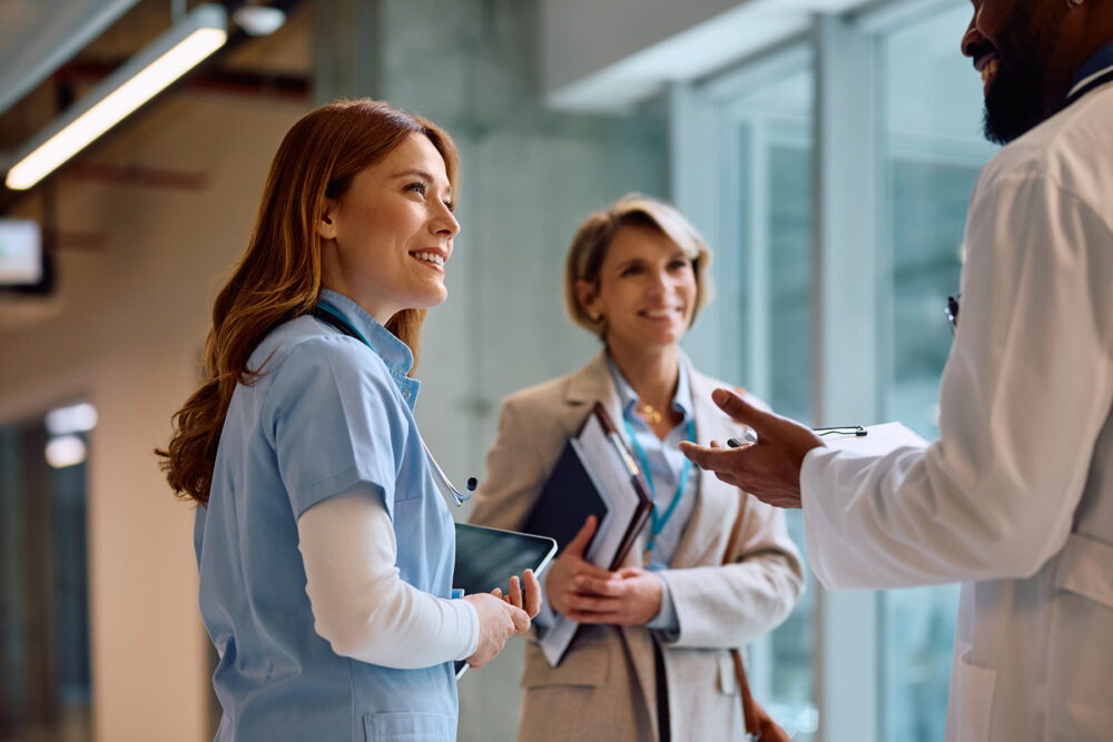 nurse smiling while talking to doctor and hospital HR professional