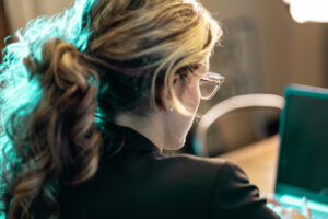 close up of woman sitting at a desk working on a laptop