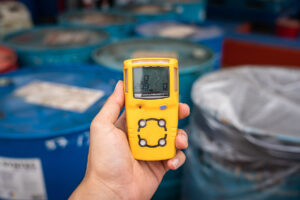 a hand holding an h2s monitor while detecting for the hazard gas