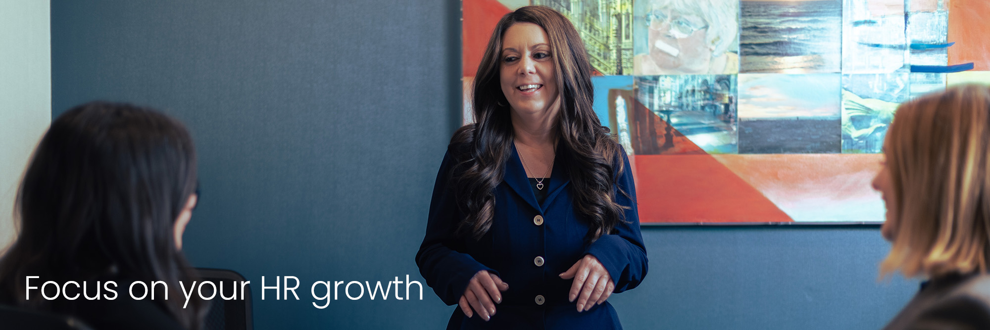 hr leader standing at the head of a board room while meeting with subordinates