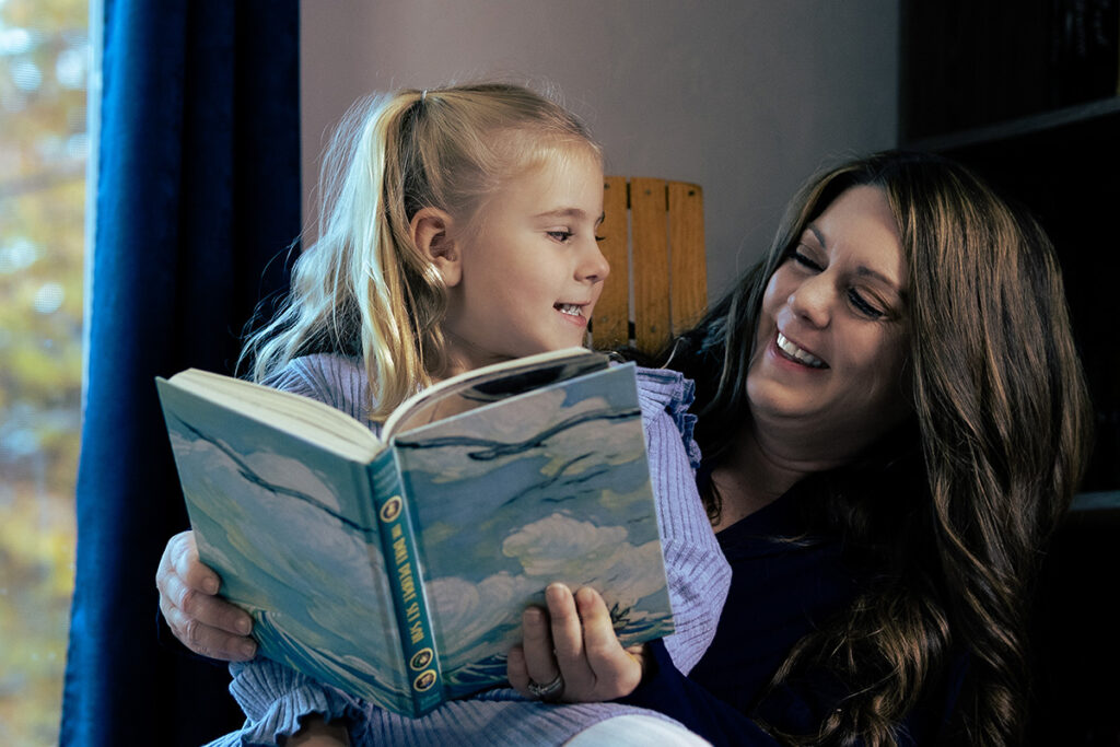 a businesswoman sharing a moment with her daughter while reading a book