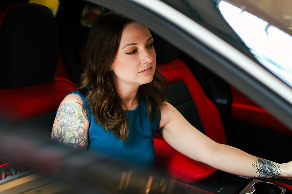 woman sitting in a chevrolet testing various features on the dashboard