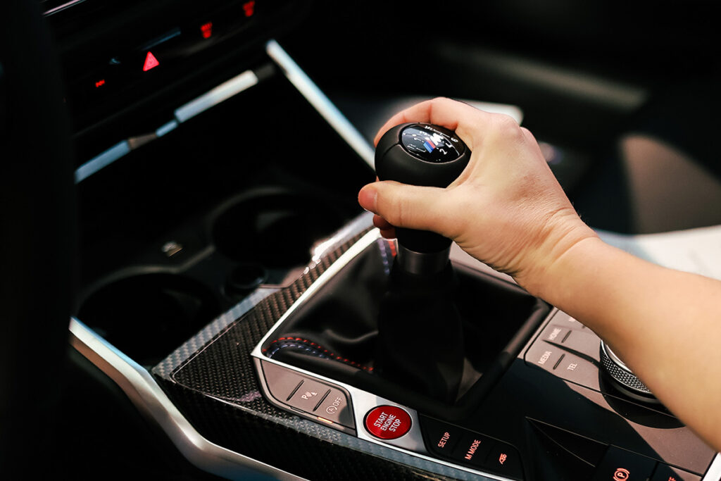 hand resting on a manual transmission shift in a bmw