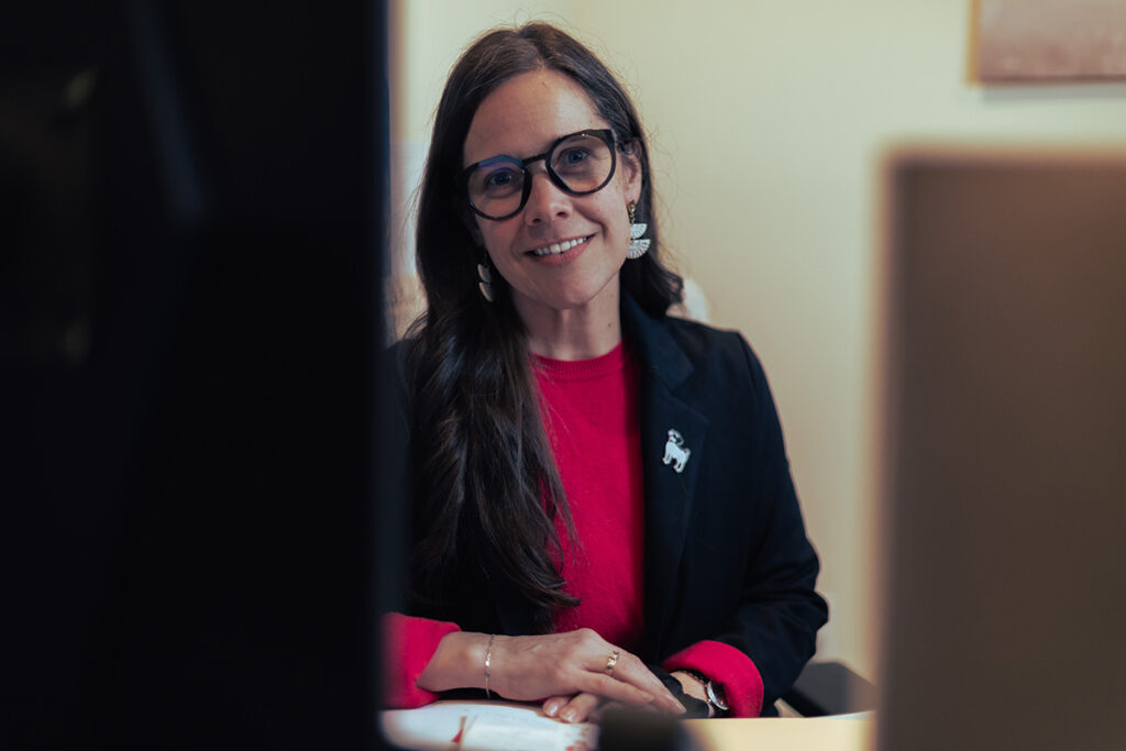 payroll manager smiling confidently sitting behind her desk