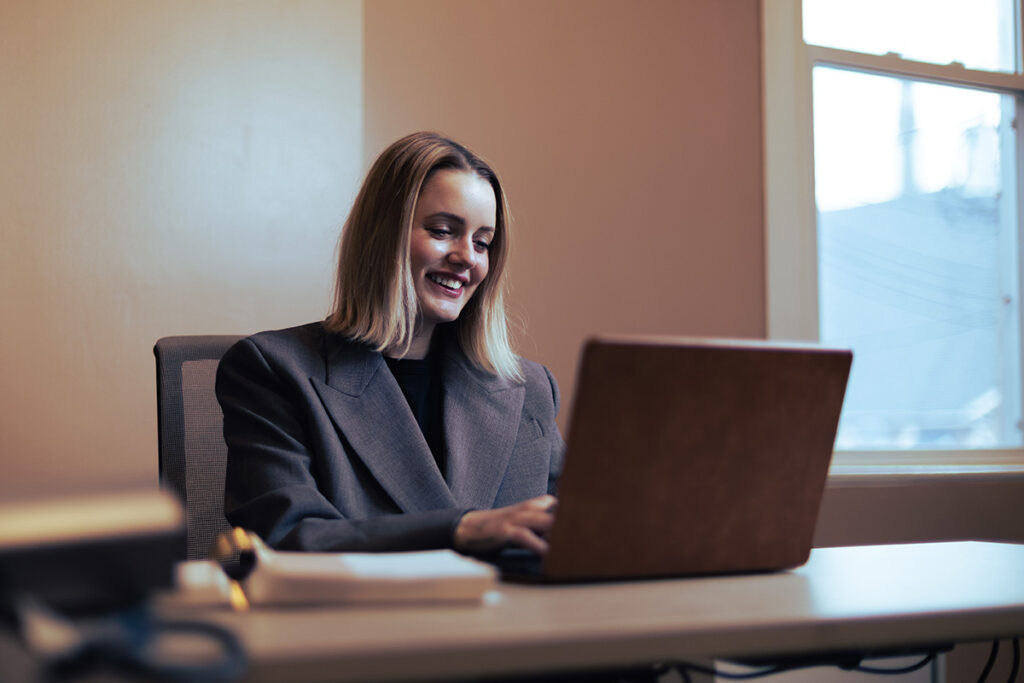 an hr tech assistant works on a project on a laptop