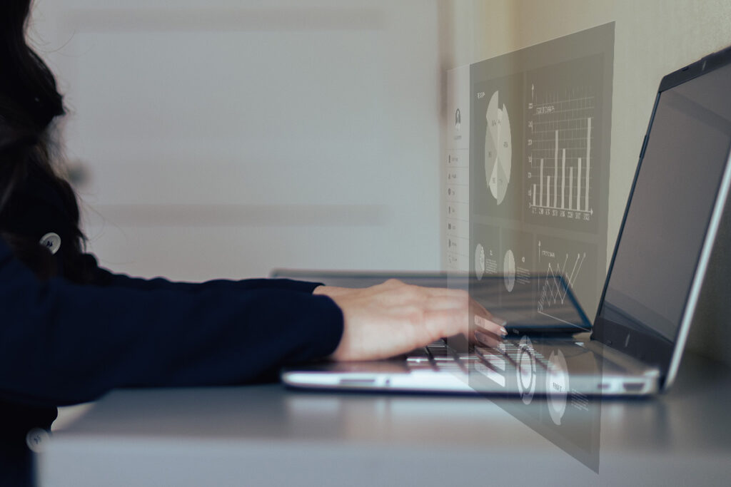 hr leader typing on computer while charts and graphs appear hovering above her screen
