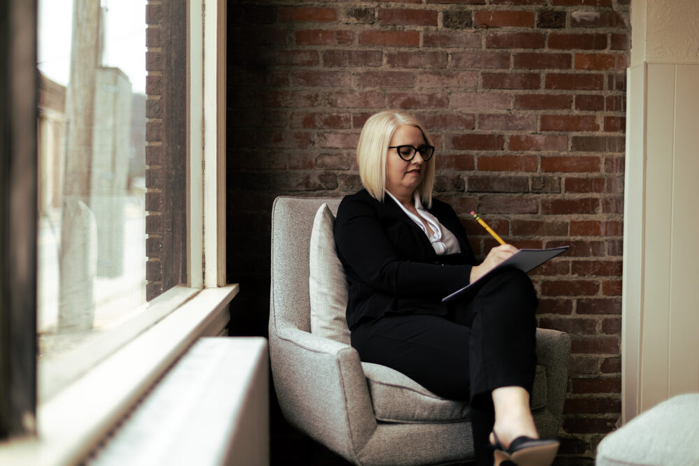 hr leader working on a soft, cushioned chair by a window in her office