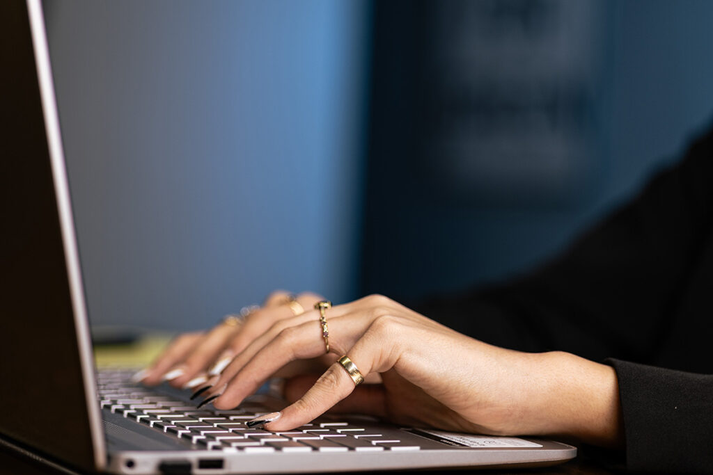 hr assistant hands typing on a laptop